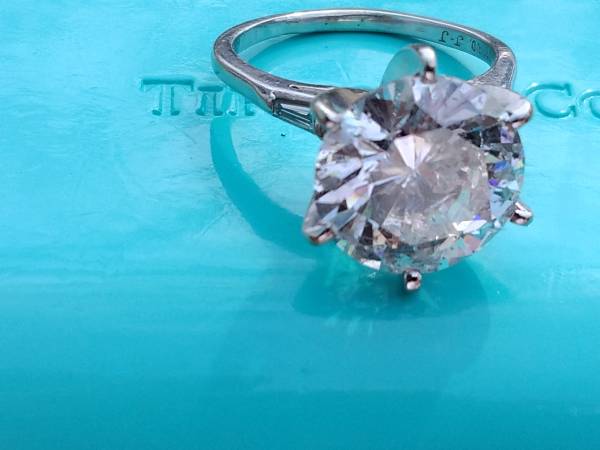 A diamond ring sitting on top of a blue sheet.