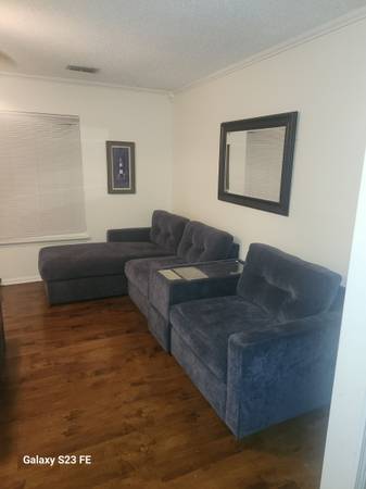 A living room with blue furniture and a mirror.