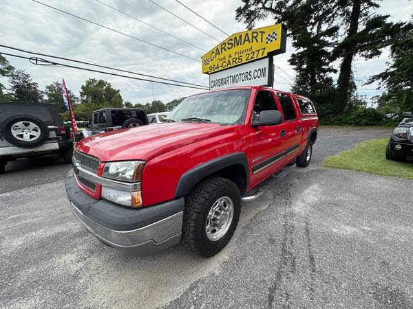 A red truck parked in front of a store.