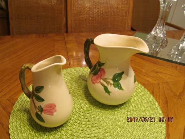 A green table with two pitchers on it