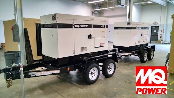 Two generators are parked on a trailer.
