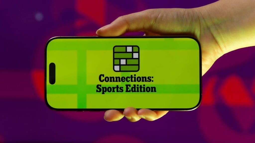 A person holding up a cell phone with the words connections sports edition on it.