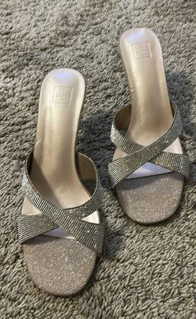 A pair of silver shoes sitting on top of the carpet.