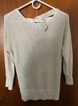 A white sweater with a bow on the back.