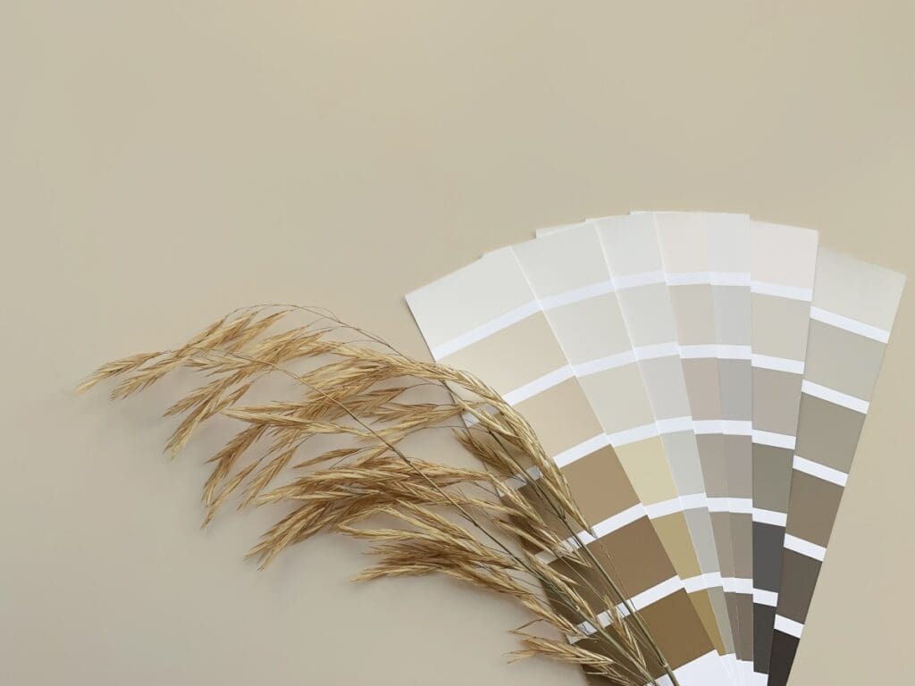 Concept: nature inspires colors. Samples of paints with dried grass on a beige background. Neutral beige and gray color palette for decorating and design. Natural pastel colors for home renovation