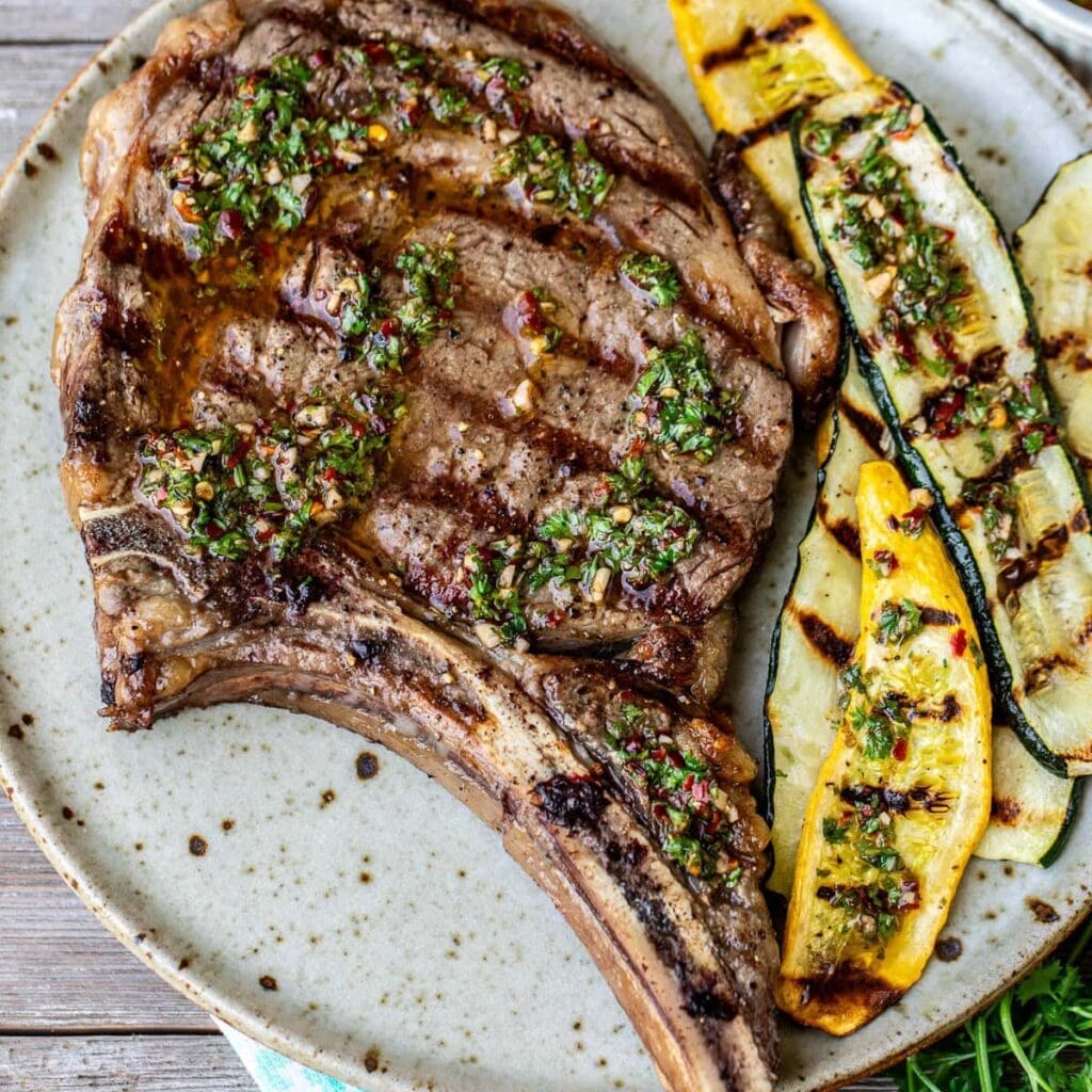 Grilled steak with chimichurri and vegetables.