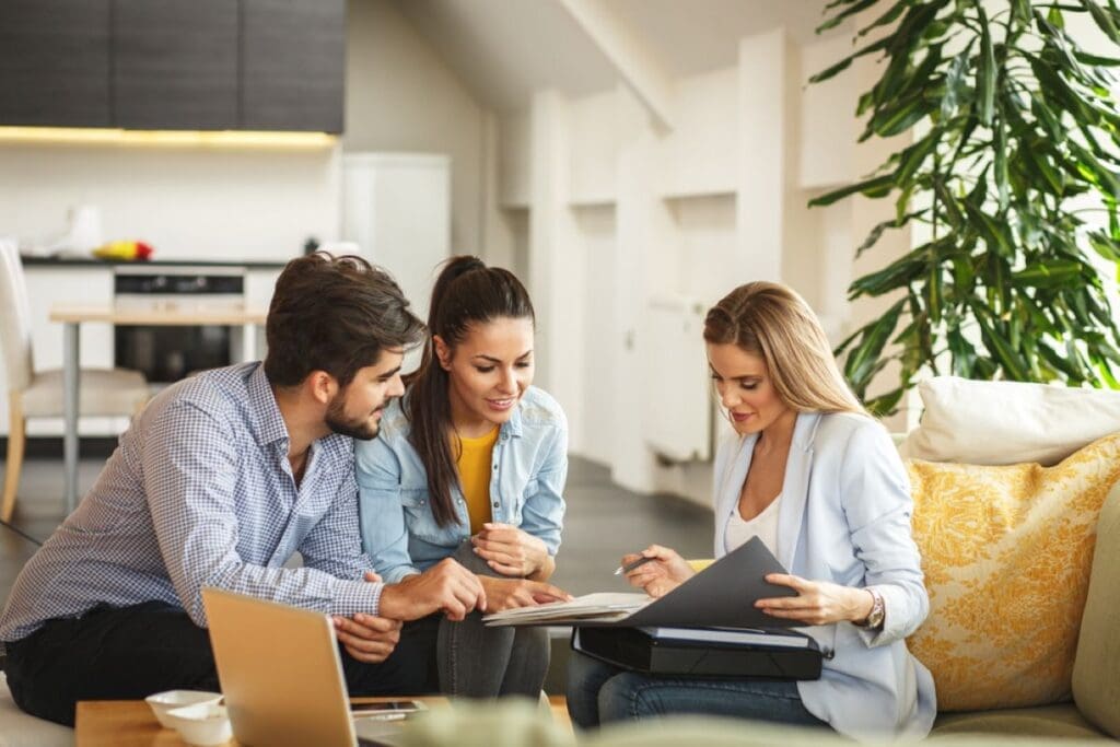 A couple looking over a home inspection report and real estate paper work with their agent