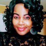 Smiling woman with curly hair indoors.